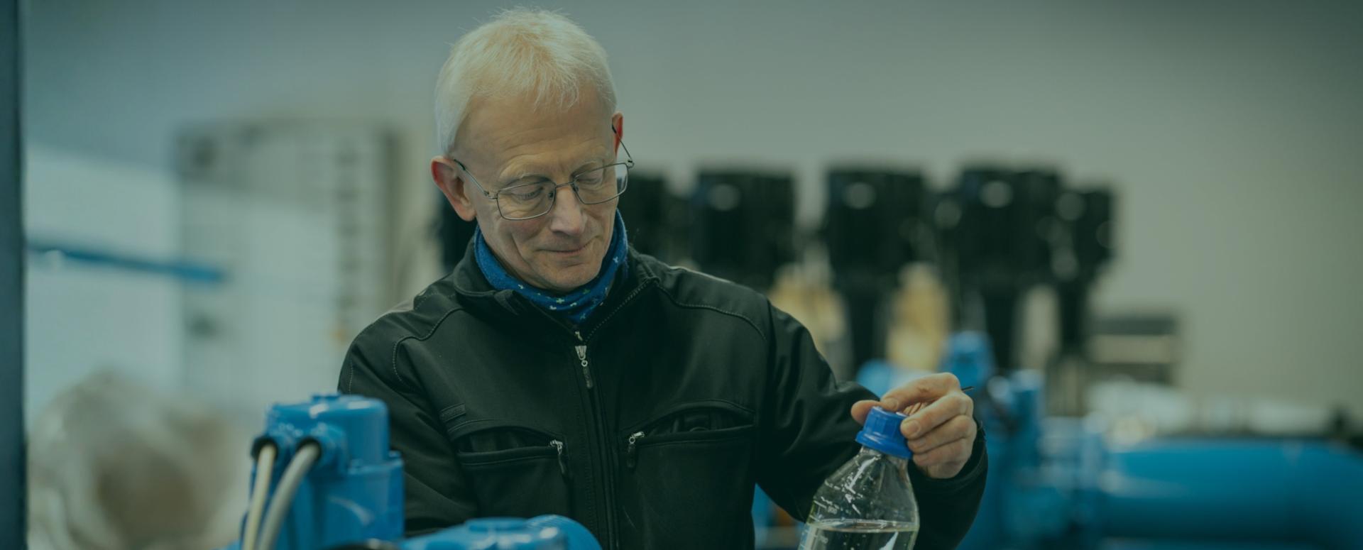 Medarbejder der står med en vandprøve